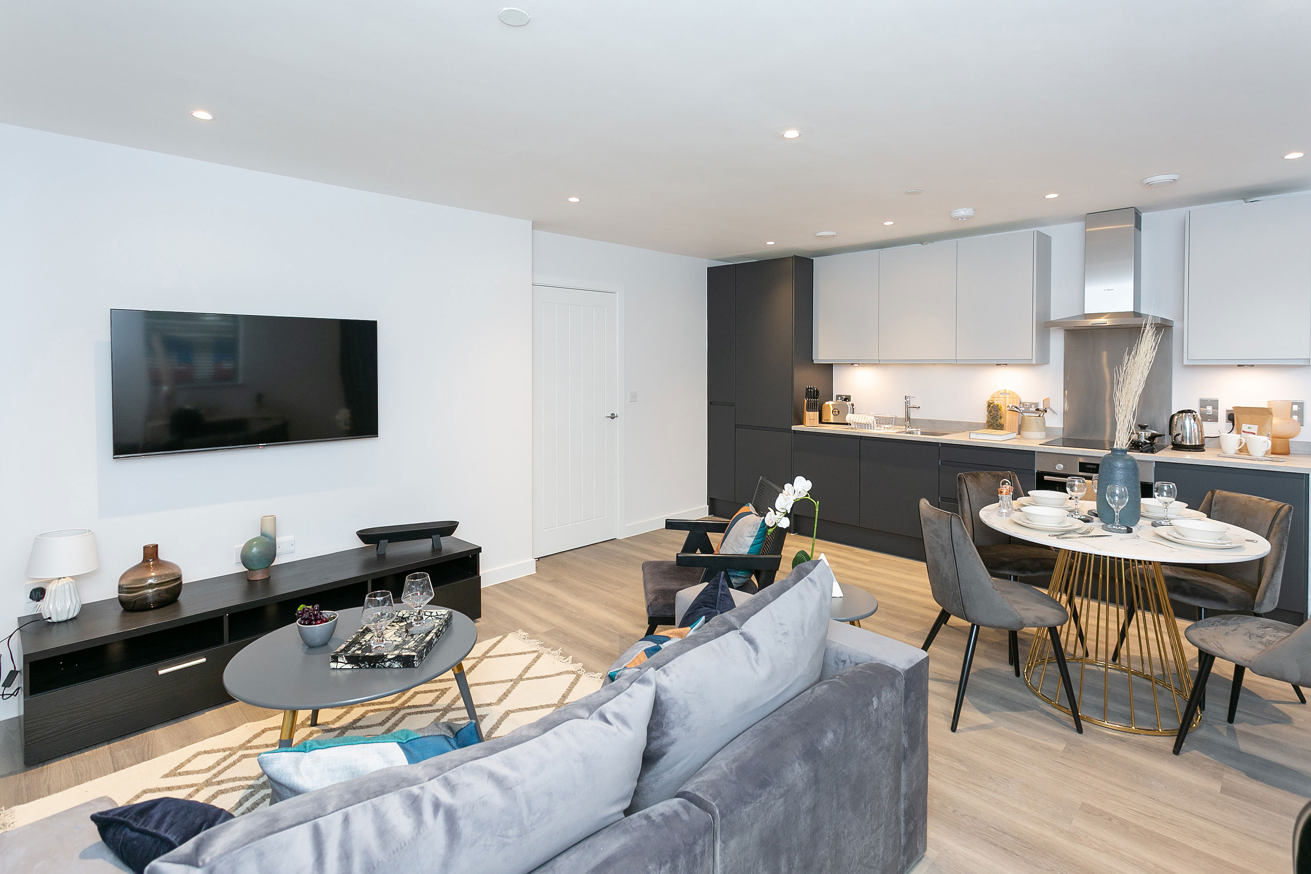 Open plan living room, kitchen & dining room with wall mounted tv. 