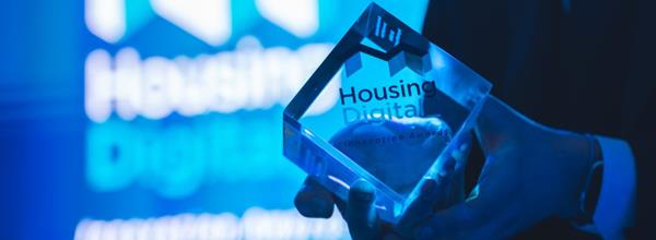 housing digital innovation award trophy in front of projection screen
