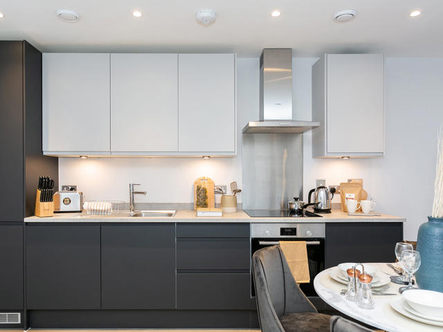 Modern fitted kitchen with dark grey & white cupboards